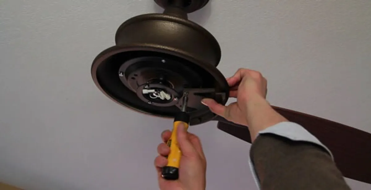 Electrician installing ceiling fan mounting bracket and fixture in Memphis, TN