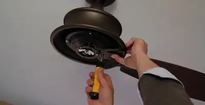 Electrician installing ceiling fan mounting bracket and fixture in Memphis, TN