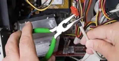 Licensed electrical contractor performing electrical repair with tools in Olive Branch, MS