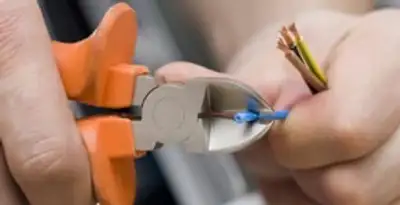 licensed electrician performing precise wire cutting and preparation during electrical service in Memphis, TN