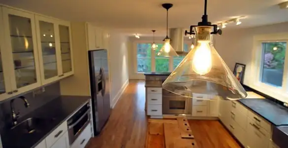 Residential electrician installing modern indoor light fixture in a home in Memphis, TN