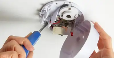 Certified technician wiring smoke detector during installation in Memphis, TN